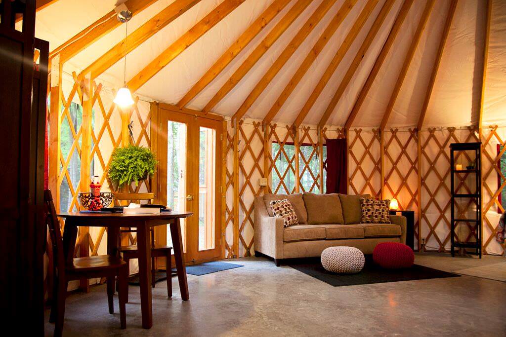 Bright yurt living area with large windows, natural light, and hardwood floors